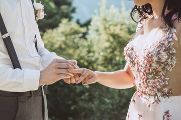 The groom or husband puts the ring on the bride or wife of the wedding ceremony. Wedding event.