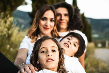 Portrait of a happy and funny young family outdoors
