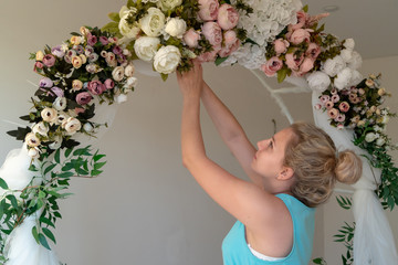 girl makes wedding, festive arch of flowers