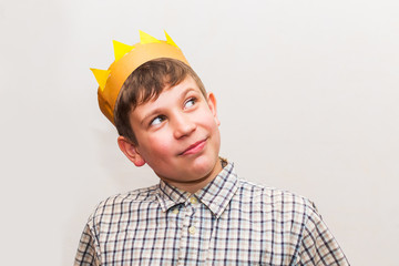 teen boy with crown on head on white background