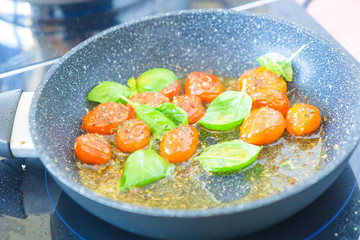 Tomatoes are fried in a pan