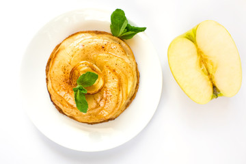 Fresh appetizing round cake made of apple charlotte with mint leaves and half an apple close up on...