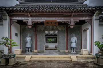 Traditionelles japanisches Haus mit Figuren im  Eingangsbereich in einem Japangarten