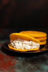 Latin American breakfast Arepas (arepa) of ground maize dough with cheese and herbs. Cuisine of Venezuela and Colombia. Close-up view, dark background, copy space