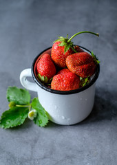 Bowl with red strawberries at dark wooden background,closeup