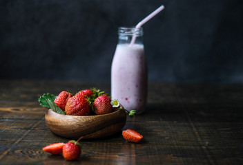 Bowl with red strawberries at dark wooden background,closeup