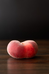 Fresh organic saturn peaches on a dark wooden table © Julia Fateyeva