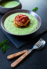 Traditional Australian dish called Pie Floater. Green pea soup served with Australian meat pie. Australian cuisine. Black background. Close-up. Copy space