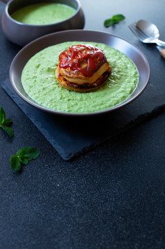 Traditional Australian dish called Pie Floater. Green pea soup served with Australian meat pie. Australian cuisine. Black background. Close-up. Copy space