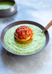 Traditional Australian dish called Pie Floater. Green pea soup served with Australian meat pie. Australian cuisine. Black background. Close-up. Copy space