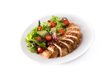 Grilled chicken breast with vegetables on a plate isolated on white background