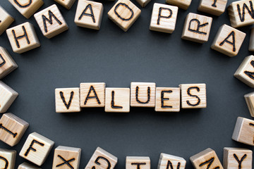 word values composed of wooden cubes with letters, core values are the fundamental beliefs concept, scattered around the cubes random letters, top view on gray background