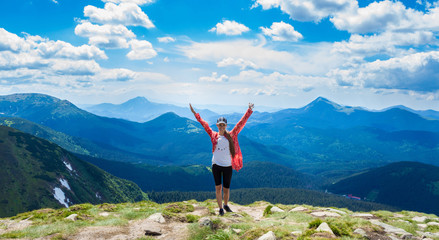 Happy hiker with her arms outstretched, freedom and happiness, achievement in mountains. Copy space