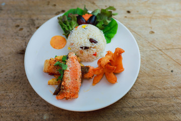 Salmon with Rice and Vegetables: A delectable salmon steak, grilled to perfection, served alongside...