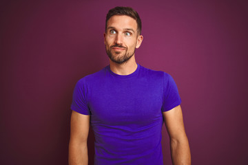 Obraz premium Young man wearing casual purple t-shirt over lilac isolated background smiling looking to the side and staring away thinking.