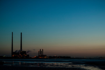 Obraz premium Poolbeg Gas/Oil Power Station seen from Sandymount strand, Dublin, Ireland. Early morning