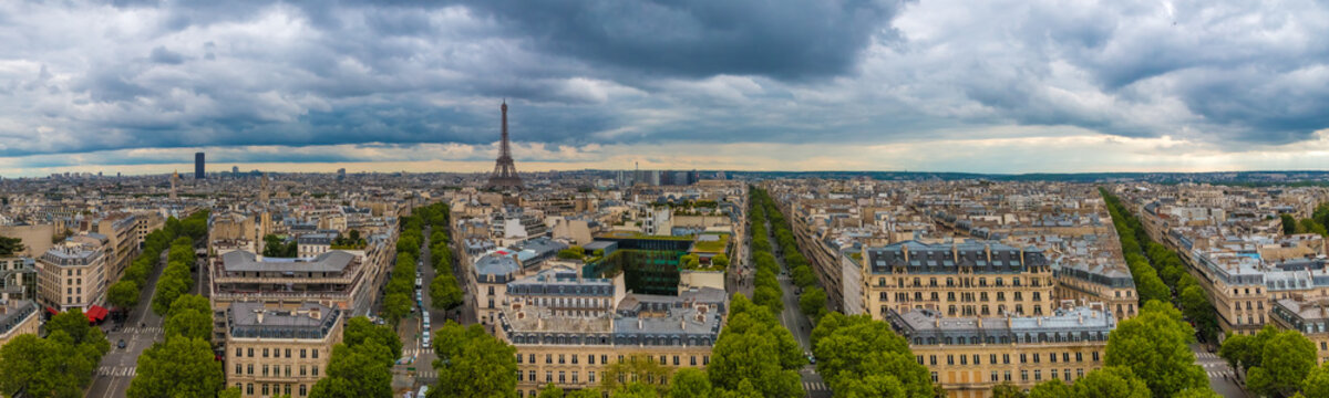 Large aerial panorama picture of the Paris cityscape with the Tour Montparnasse and the Eiffel Tower including Avenue Marceau, Avenue d'Iéna, Avenue Kléber and Avenue Victor-Hugo on a cloudy day.