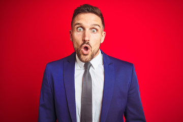 Young handsome business man over red isolated background afraid and shocked with surprise expression, fear and excited face.