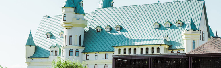 panoramic shot of luxury house with blue roof in summertime