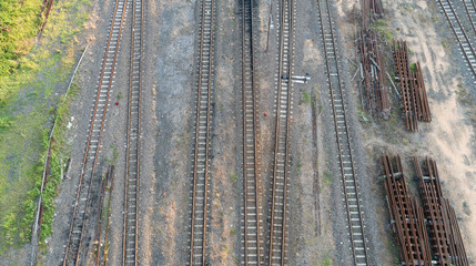 aerial top view of railroad tracks with steel bar and some weeds.