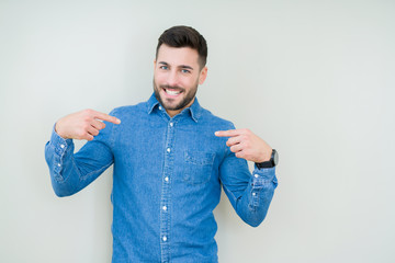 Young handsome man over isolated background looking confident with smile on face, pointing oneself...
