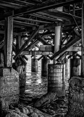 Black and White Texture with Wood Pilings and Sea under Pier