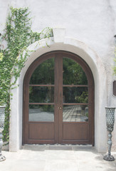 elegant wooden front door surrounded by garden