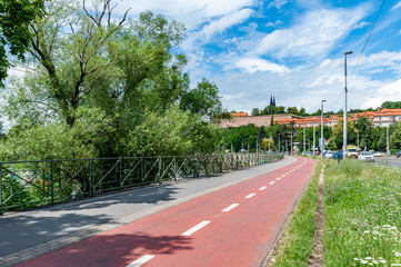 Bicycle path next to river Vltava in Prague. Summer cityscape of Prague with Vysehrad Castle in background.