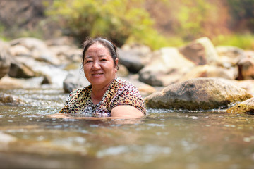 Asian woman in stream water for relaxing on vacation