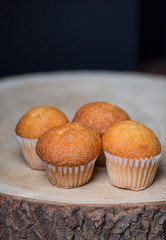 Four cupcakes on wooden board. Vertical shoot of sweet breakfast.