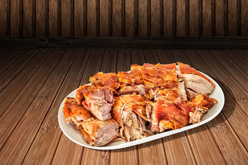 Plateful of Freshly Spit Roasted Pork Shoulder Slices Served on Bamboo Place Mat with Traditional Savory Appetizer Dish