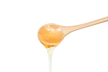 honey dripping from wooden spoon isolated on white background