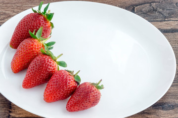 Ripe strawberries on white plate