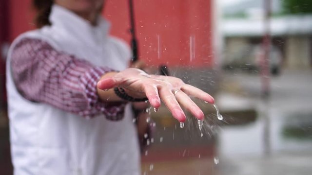 girl catches the rain drops on the palm