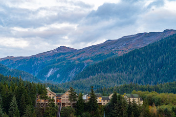Traditional charming brown cabin lodge duplex homes nestled in the mountains among pine trees with...