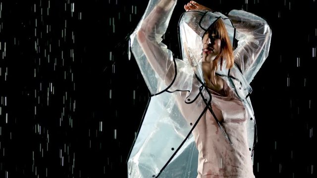 Beautiful woman dancing in the rain. Slow Motion.