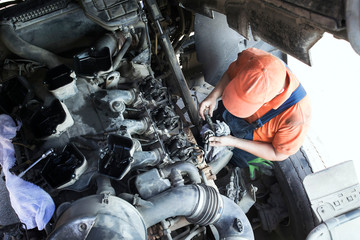 Mechanic repairs a truck.  adjustment of valves of the diesel motor.  Replacement nozzles.