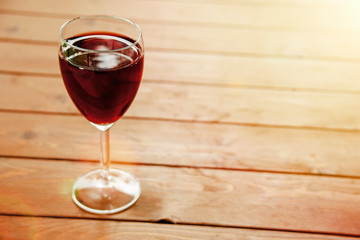 Glass of red wine on wooden table top view