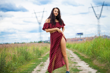 Young beautiful woman in dress in the summer park