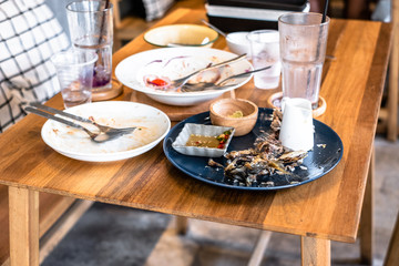 Dirty dishes of leftover food on table in restaurant.