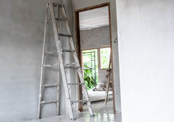 Home improvement concept with steel ladder and white wall in empty room