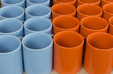 Orange and blue ceramic cup or mugs for input drink water or coffee or tea,horizontal set two tone color,object background