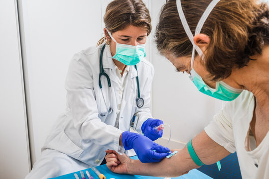 female doctor drawing blood to a patient with risk of infection