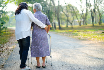 Help and care Asian senior or elderly old lady woman use walker with strong health while walking at...