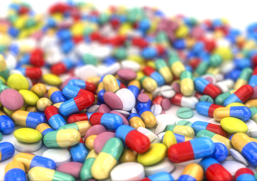 Different pills and capsules placed on a table, with shallow depth of field.