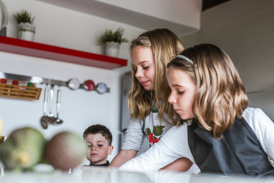 Little girls and boy Kids playing while while cooking healthy salad in kitchen together