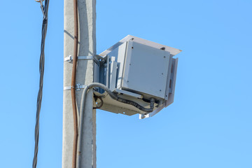 Speed camera car for surveillance on highway, tool of police for control road traffic. Speed radar cameras mounted on concrete pole against a clear blue sky. Speed control.