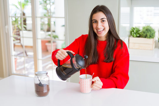 Young beautiful woman making morning coffee smiling, preparing a cup of latte for breakfast