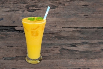 Mango smoothies juice orange fruit juice milkshake blend beverage healthy high protein the taste yummy in glass episode drink morning on wood background.