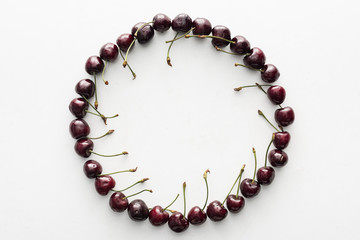 flat lay with fresh, whole and ripe cherries covered with water drops